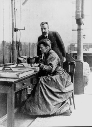 Pierre et Marie Curie dans le laboratoire, dit le “hangar de la découverte” de l’École municipale de Physique et de Chimie industrielles, vers décembre 1903