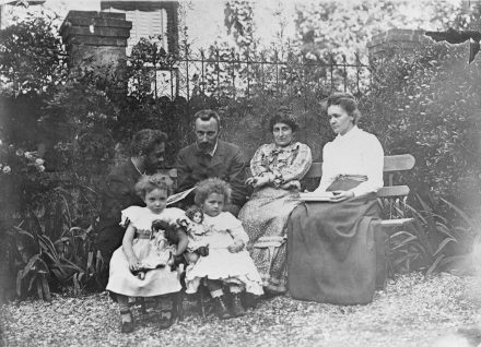 Dans le jardin des Perrin, boulevard Kellerman, 1902. De gauche à droite, devant, Irène Curie, Aline Perrin, derrière : Jean Perrin, Pierre Curie, Henriette Perrin, Marie Curie.